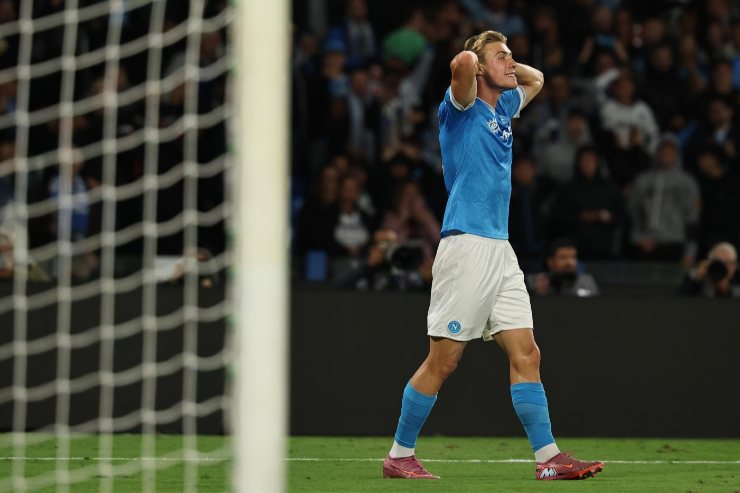 Rasmus Højlund del Napoli, con le mani tra i capelli, visibilmente frustrato dopo un errore in partita. La scena cattura un momento di delusione durante il match.