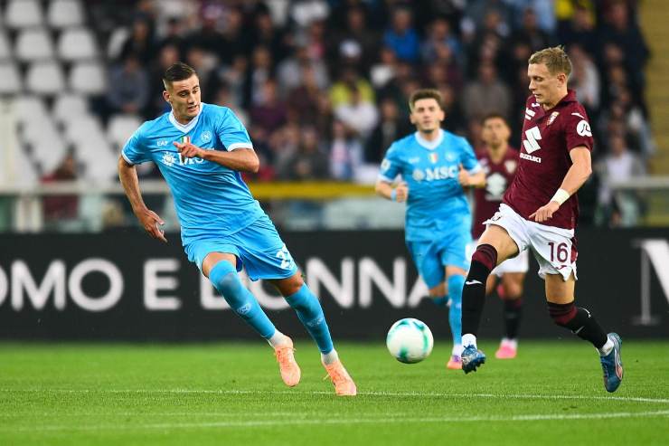 Un giocatore del Napoli in azione durante una partita contro il Torino, contrastato da un avversario granata.