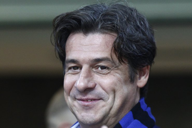 Nicola Berti, ex centrocampista dell’Inter, posa sorridente con una sciarpa nerazzurra allo stadio di San Siro.