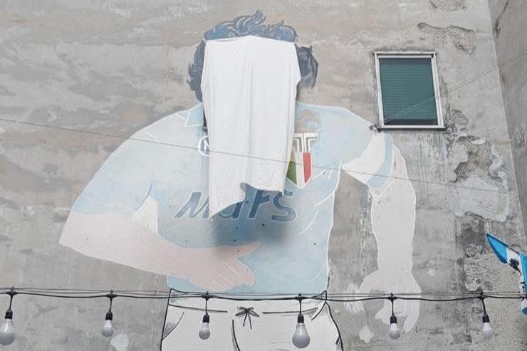Il volto del murale di Diego Armando Maradona a Napoli coperto con un telo bianco durante la protesta a Largo Maradona.