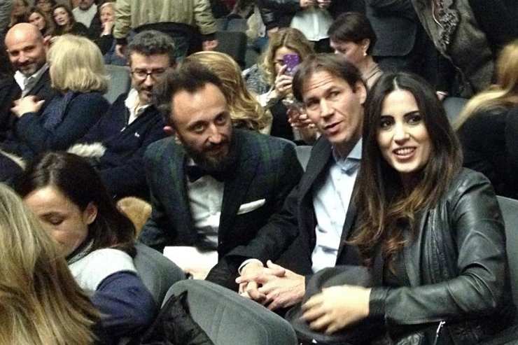 L’ex allenatore del Napoli Rudi Garcia e sua moglie assistono a un evento pubblico insieme, circondati dal pubblico in sala.