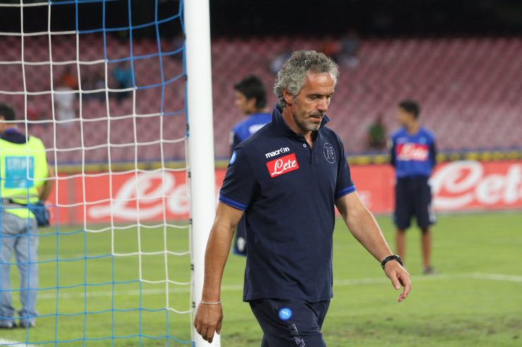Roberto Donadoni cammina sul campo del Napoli dopo l’allenamento, con sguardo concentrato e divisa ufficiale del club azzurro.