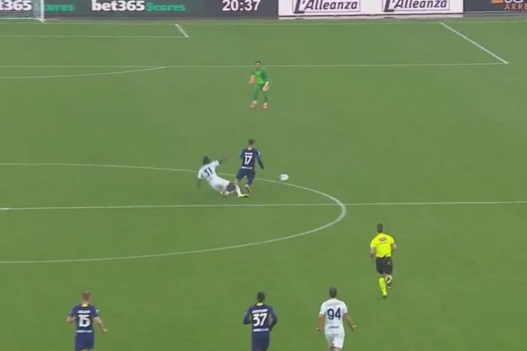 Azione contestata tra Yann Bisseck e Giovane durante la partita Verona-Inter, con il difensore nerazzurro in scivolata e l’arbitro che osserva da vicino.