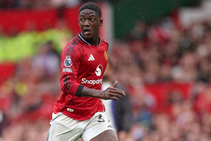 Kobbie Mainoo in azione con la maglia del Manchester United durante una partita di campionato allo stadio Old Trafford