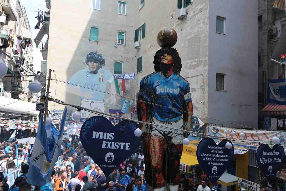 Veduta del Largo Maradona nei Quartieri Spagnoli di Napoli con murales di Diego Armando Maradona e folla in festa nel 2025.