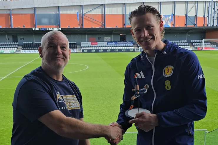 Scott McTominay riceve una statuetta commemorativa da un rappresentante dell'Atac durante una cerimonia allo stadio