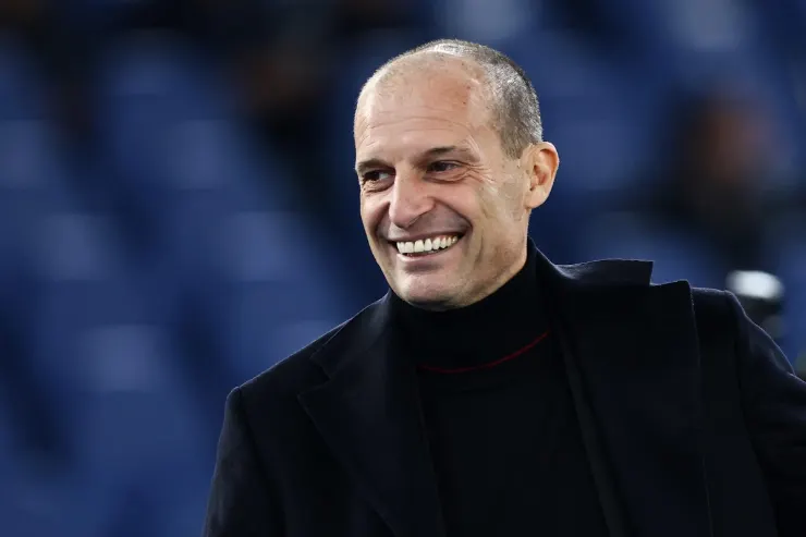 Massimiliano Allegri sorride durante un evento, indossa un cappotto nero
