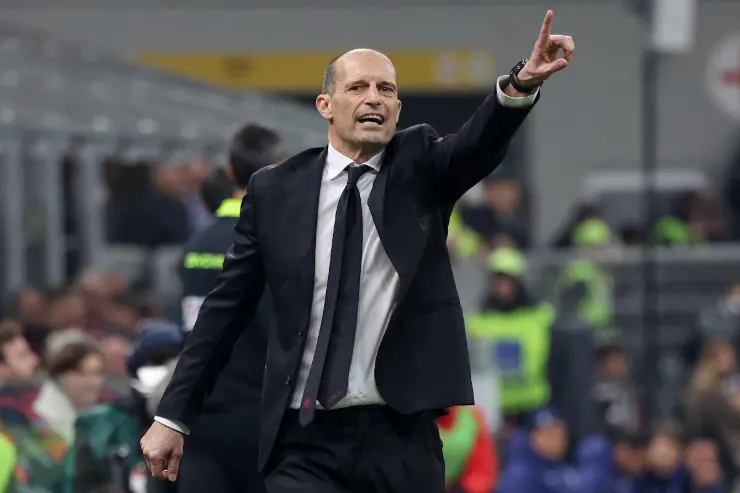 Massimiliano Allegri in panchina con giacca e cravatta nera, gesticola durante una partita