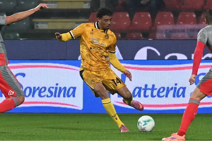 Giocatore in maglia gialla controlla il pallone durante una partita di calcio