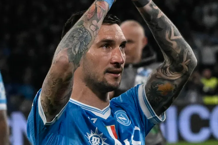 Matteo Politano con le braccia sollevate indossa la maglia blu del Napoli durante una partita