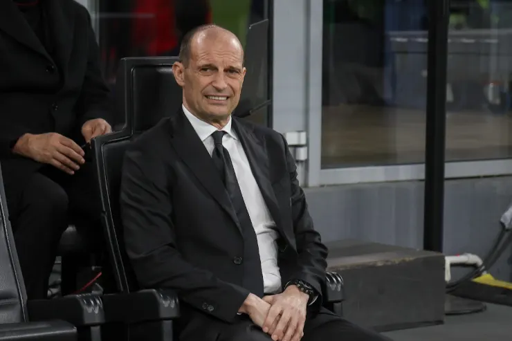 Massimiliano Allegri in abito scuro seduto in panchina durante una partita