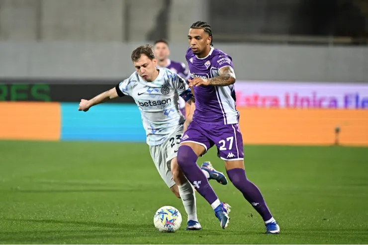 Ndour in maglia Fiorentina viola durante uno scontro di gioco con avversario in bianco