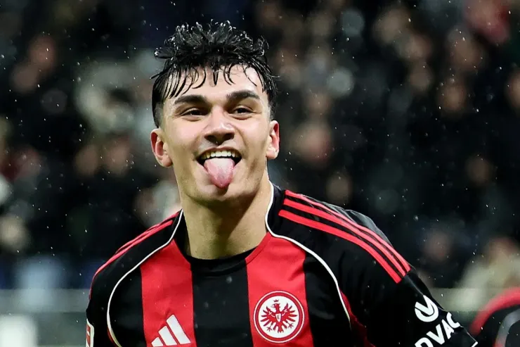 Can Uzun con la lingua di fuori, indossa la divisa dell'Eintracht Francoforte con le strisce rosse e nere