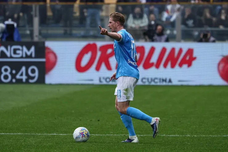 Giocatore in maglia azzurra durante una partita di calcio, in possesso del pallone