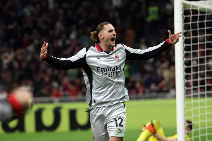Rabiot esulta in divisa Milan durante una partita, con le braccia aperte verso il pubblico dello stadio