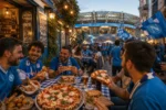 Tifosi del Napoli mangiano pizza e street food in una piazza vicino allo Stadio Maradona