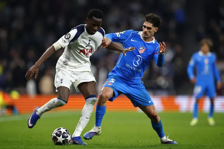 Sarr del Tottenham in azione durante una partita di Champions League, contrasto di gioco con avversario in maglia blu