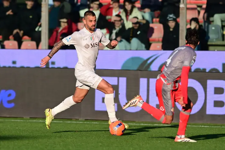 Spinazzola in azione durante una partita del Napoli, con pallone ai piedi e avversario in rosso sullo sfondo