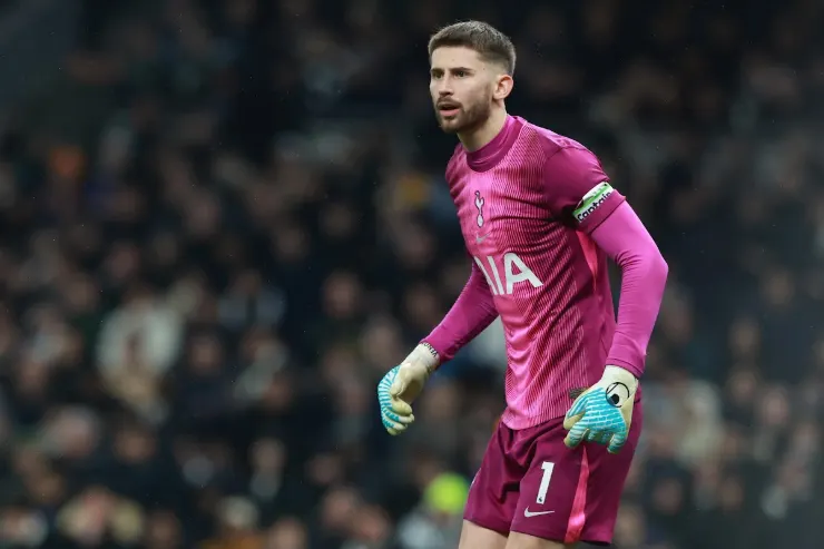 Vicario in divisa da portiere rosa del Tottenham durante una partita, con fascia da capitano al braccio