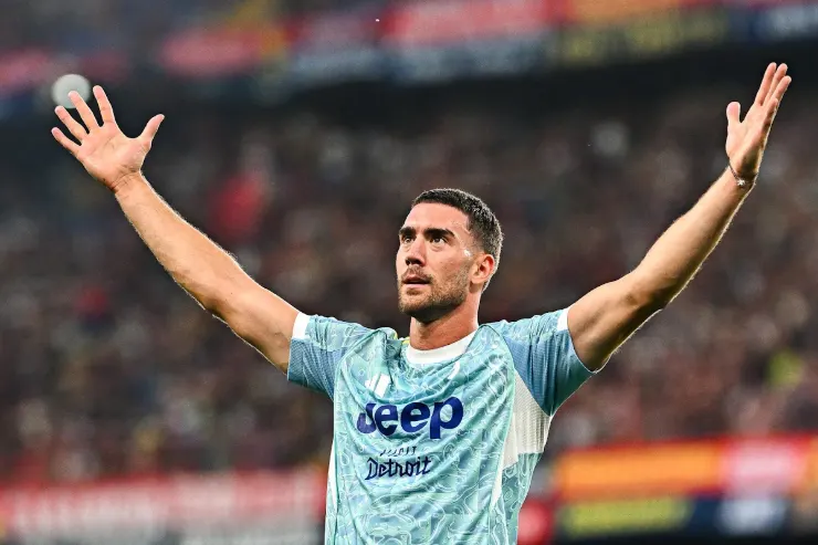 Vlahovic esulta con le braccia alzate indossando la maglia della Juventus durante una partita