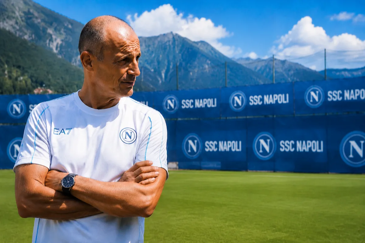 Massimiliano Allegri in maglia SSC Napoli a Dimaro, braccia incrociate, con sfondo montagne e striscioni del club