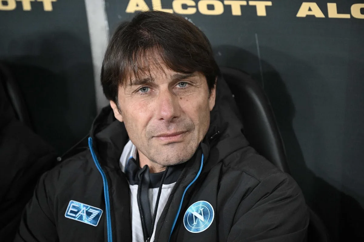 Antonio Conte in panchina con tuta tecnica EA7 e logo Napoli, durante una partita ufficiale