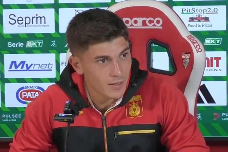 Costantino Favasuli in conferenza stampa con la tuta del Catanzaro, davanti al pannello sponsor