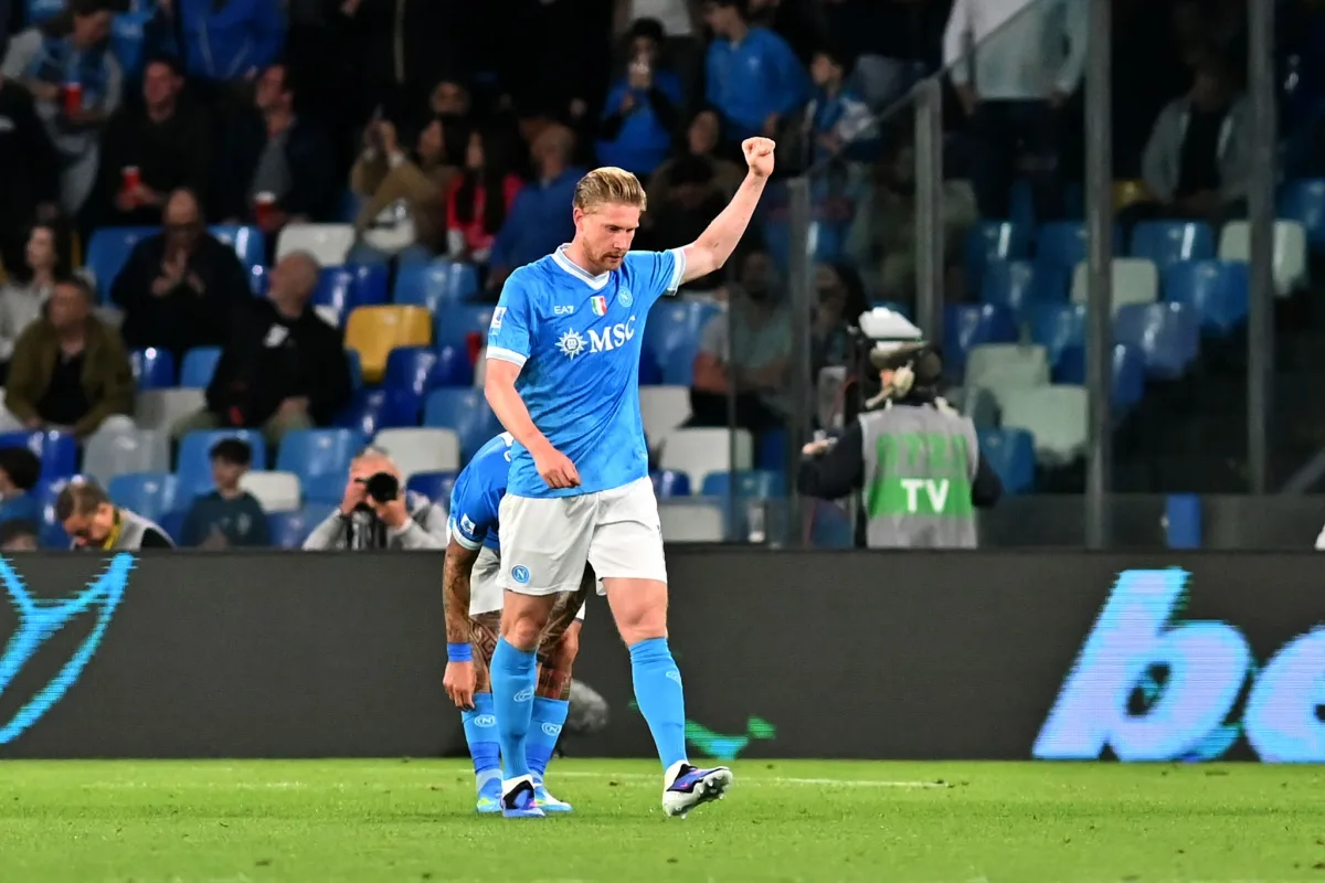Giocatore del Napoli in maglia azzurra esulta con il pugno chiuso durante una partita allo stadio