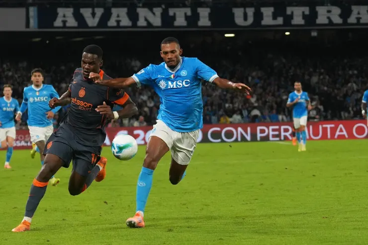Juan Jesus in maglia Napoli azzurra contende il pallone a un giocatore avversario durante una partita