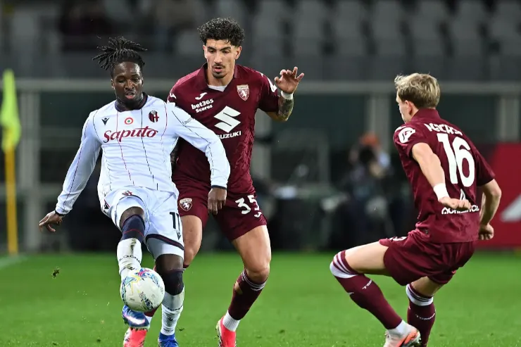Marianucci in azione con il pallone durante una partita di calcio, contrastato da due difensori avversari del Torino