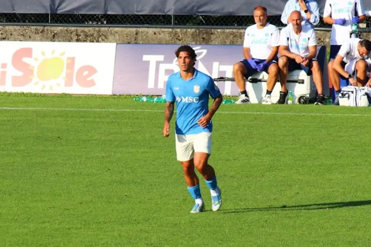 Marianucci in maglia azzurra durante l'allenamento del Napoli, con staff tecnico sugli spalti