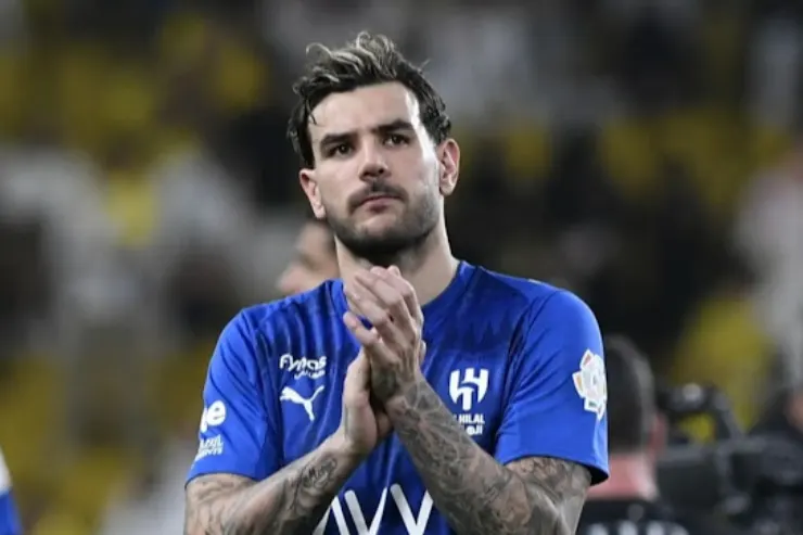 Theo Hernández in maglia blu durante una partita, con espressione concentrata e le mani giunte