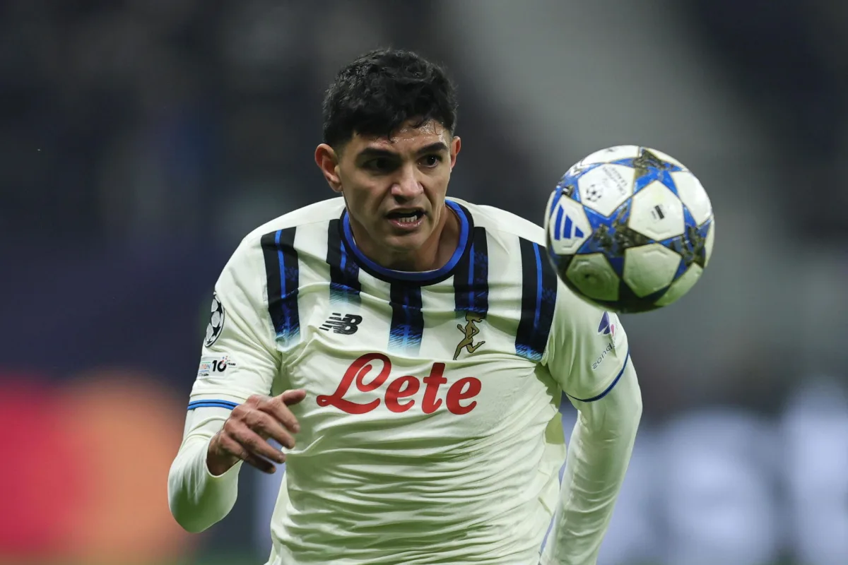Giocatore con maglia bianca e blu dell'Atalanta controlla il pallone durante una partita di Champions League