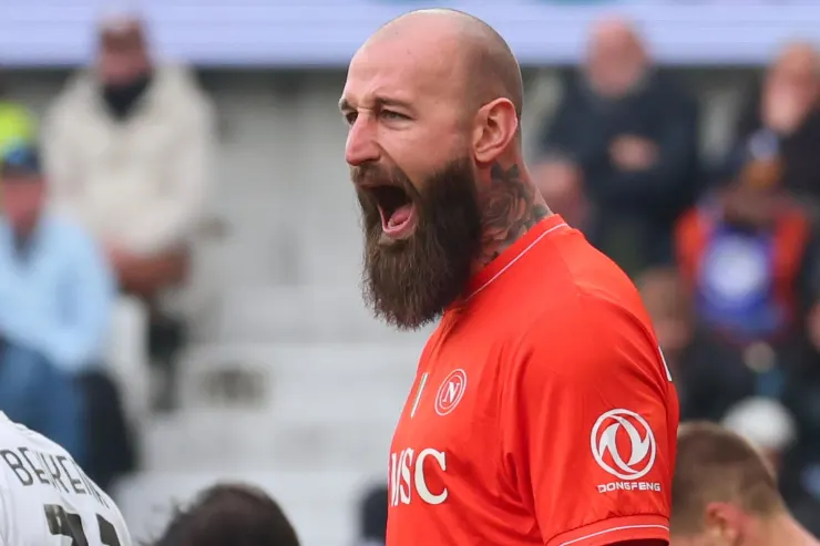 Vanja Milinkovic-Savic, calciatore con barba, celebra durante una partita indossando una maglia rossa