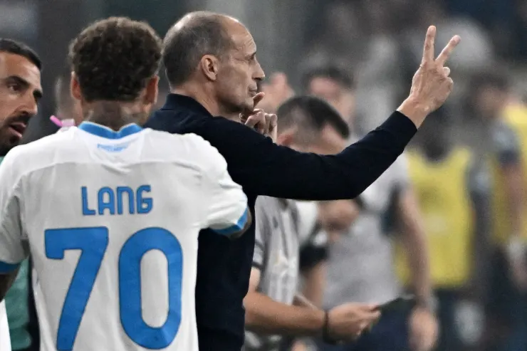 Allenatore durante una partita gesticola con le mani mentre parla con un giocatore con numero 70
