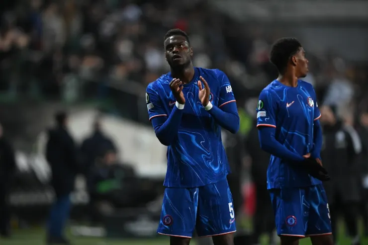 Achraf Badiashile in maglia blu durante una partita, con le mani giunte in gesto di concentrazione