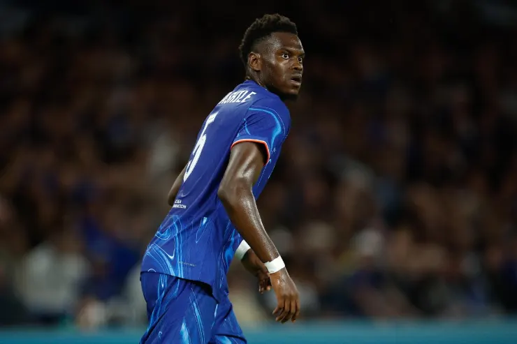 Badiashile in maglia blu del Napoli durante una partita, ripreso di profilo