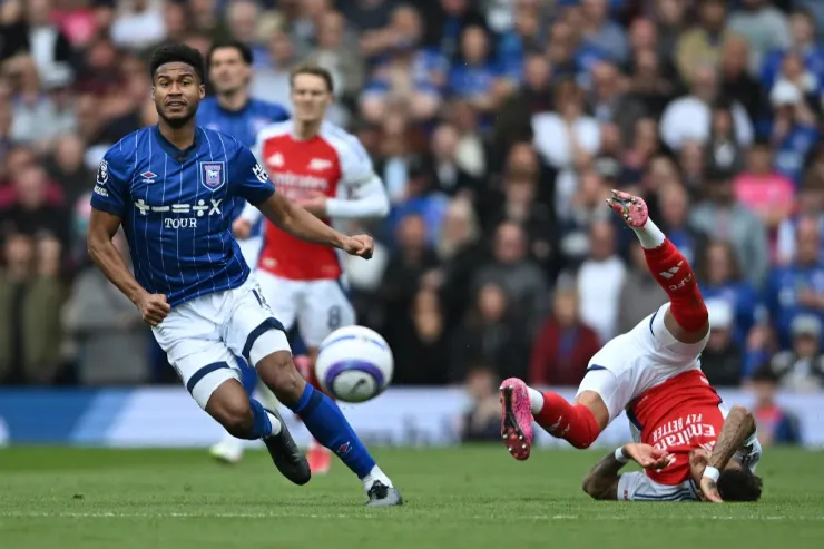 Cajuste in azione con la maglia dell'Ipswich Town contro un difensore in rosso