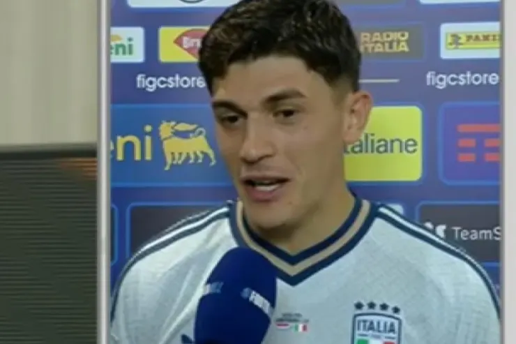 Favasuli in maglia Italia durante un'intervista con microfono, sfondo con sponsor