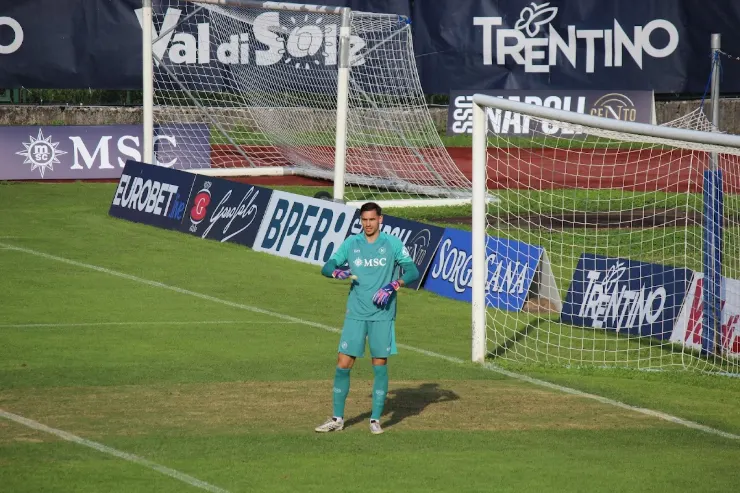 Meret in porta con divisa azzurra durante una partita del Napoli, posizionato davanti alla rete