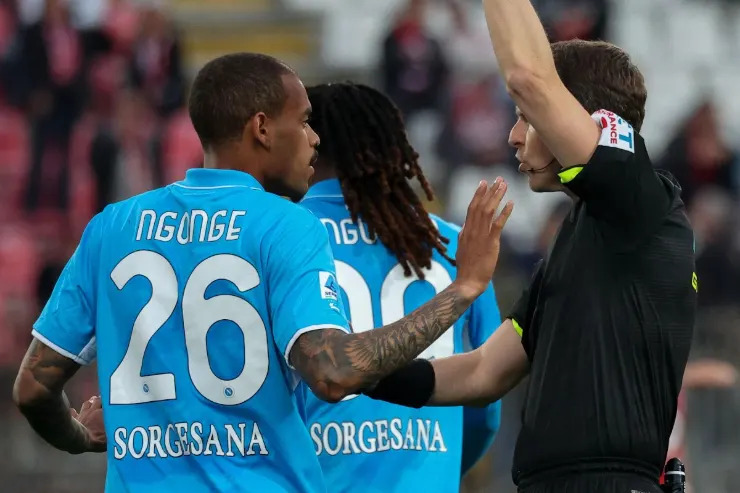 Ngonge in maglia Napoli azzurra numero 26 durante una partita, con arbitro in primo piano
