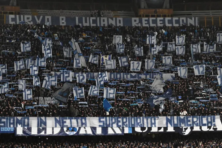 Tifosi della Curva B del Napoli in tribuna con bandiere azzurre e striscioni durante la partita