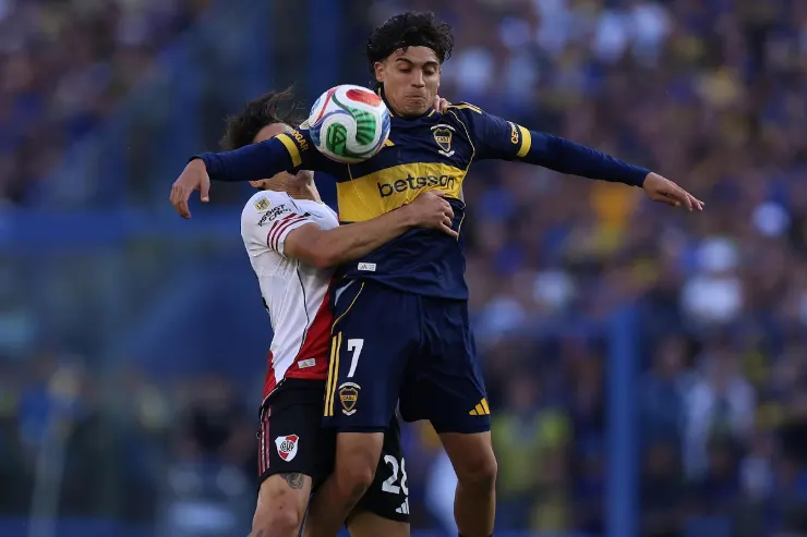 Zeballos in contrasto aereo durante una partita, indossa la maglia blu e gialla del Boca Juniors