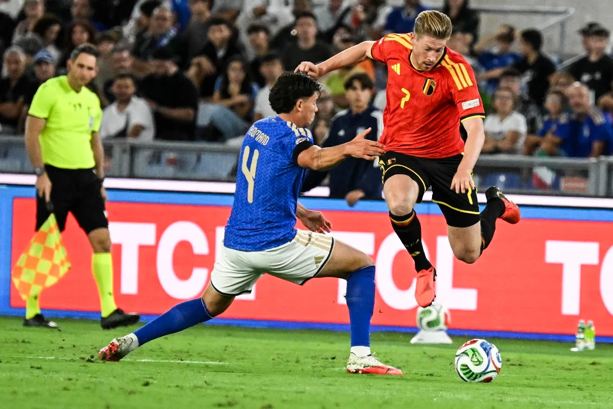 De Bruyne in maglia Belgio numero 7 durante un'azione di gioco contro l'Italia, con Romano in blu