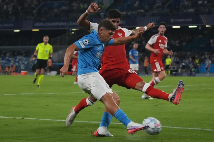 Favasuli in maglia blu del Napoli contrasta un avversario in rosso durante una partita di Champions League