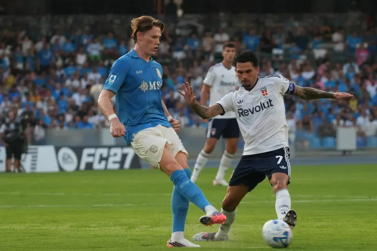 McTominay in maglia blu contrasta il pallone con un avversario in maglia bianca durante una partita di calcio
