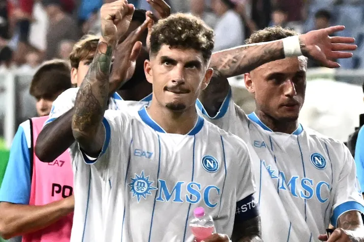 Due calciatori del Napoli con maglia bianca da trasferta con sponsor MSC, esultano davanti al pubblico dello stadio