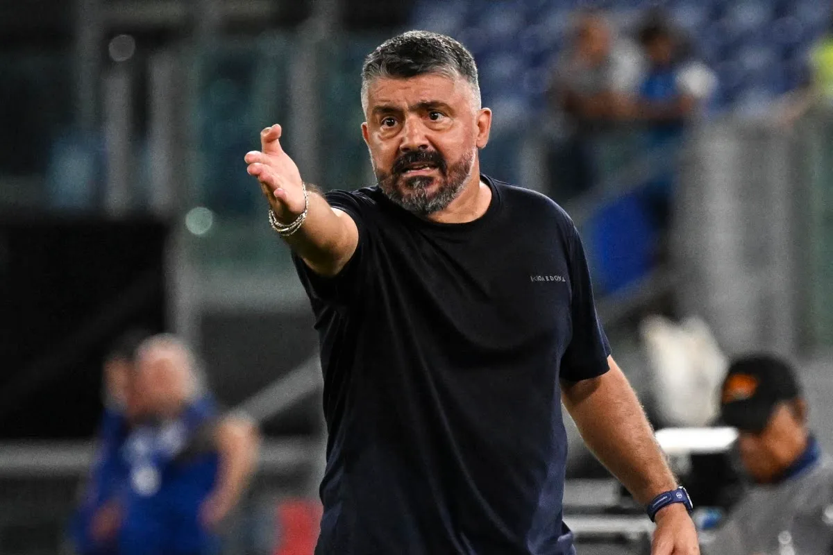 Gattuso gesticola in campo durante una partita di calcio, con lo stadio sfocato sullo sfon