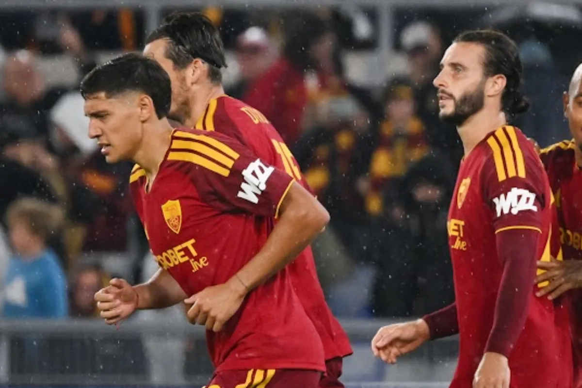 Giocatori della Roma con maglia giallorossa e sponsor Wd, sotto la pioggia durante una partita