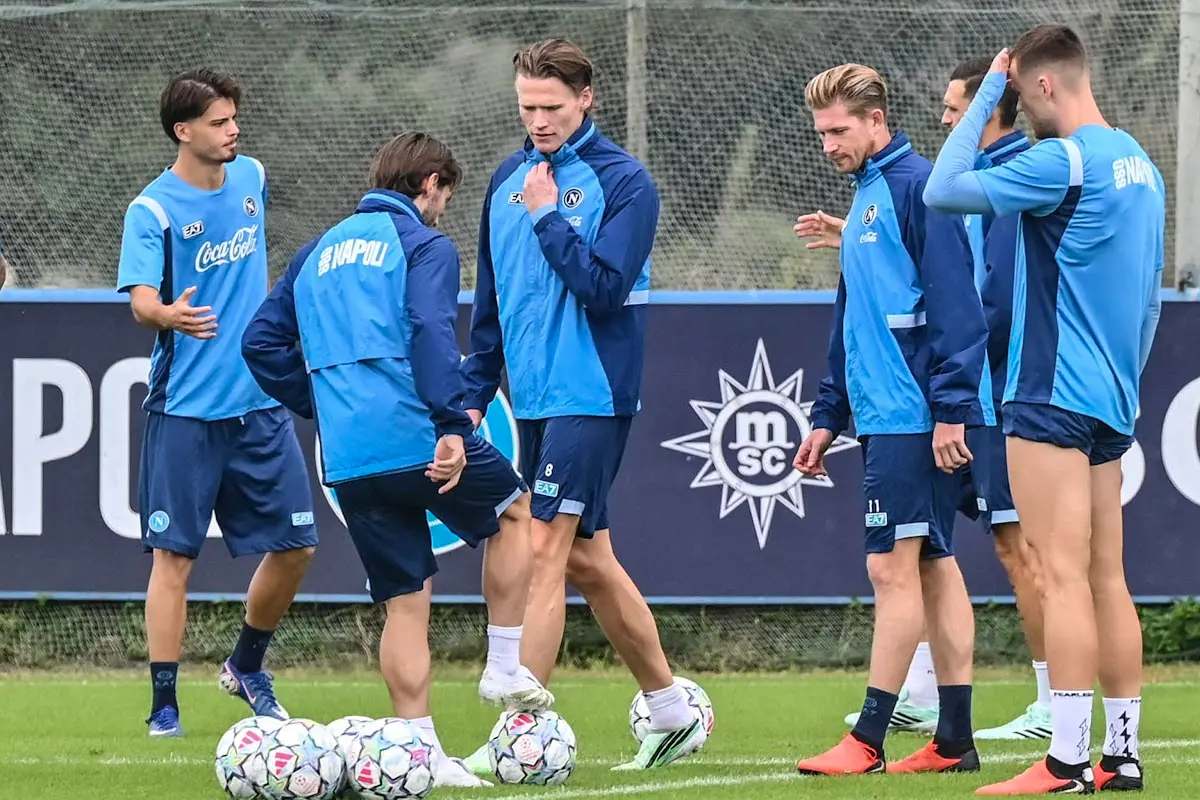 Giocatori del Napoli in allenamento sul campo con palloni, maglie azzurre e sponsor MSC sullo sfondo